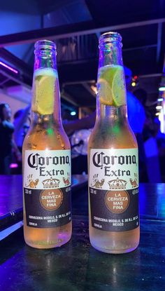 two bottles of corona beer on a bar