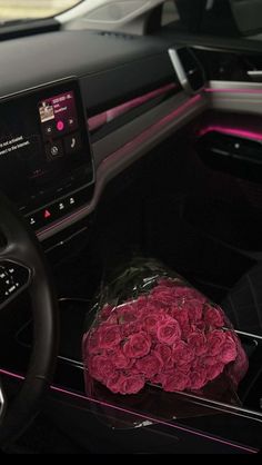 the interior of a car with pink flowers on display in front of the steering wheel