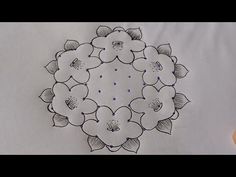 a drawing of flowers on a white table cloth with a pen and ink in it