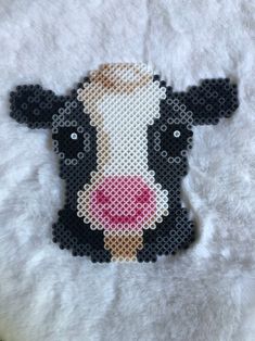 a black and white cow with a pink nose is shown in the shape of a cross stitch pattern