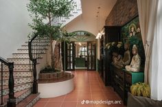 an entry way with stairs, potted plants and two women sitting on the bench