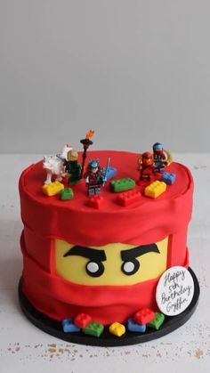 a lego themed birthday cake with lots of toys on top