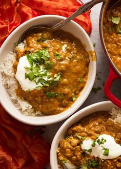 three bowls of chili and rice with sour cream on top