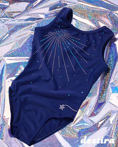 a blue swimsuit with sequins on it laying on a shiny surface in the sun