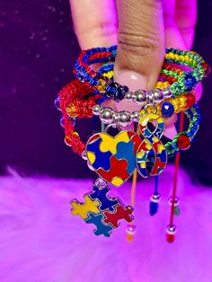 a person is holding several colorful bracelets with different designs on them and beads in the middle