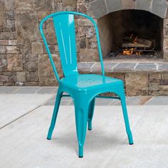 a blue chair sitting in front of a fire place