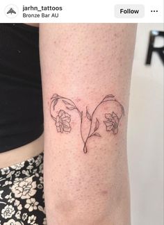 a woman's arm with two flowers on it and the word love written in black ink