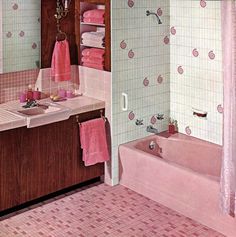 a bathroom with pink towels hanging on the wall and a bathtub in the corner