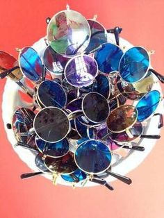 a white plate topped with lots of sunglasses on top of a red table next to a pink wall