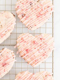 four heart shaped cookies on a cooling rack