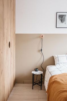 a bed sitting next to a wooden door in a bedroom on top of a hard wood floor