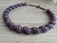 Beautiful Cellini Spiral carefully stitched by hand. At 47 cm / 18 1/4 inches, necklace will rest just at or below collarbone. Only high quality miyuki glass seed beads used, tones of purple, pink, bronze and copper. Finished with Swarovski pearls, and artist quality decorative copper toggle clasp. Handmade Spiral Beaded Necklace As Gift, Spiral Beaded Necklace As Gift, Spiral Beaded Necklace For Gift, Spiral Beaded Necklace For Gifts, Spiral Colorful Beads For Jewelry Making, Spiral Beaded Necklaces As Gifts, Colorful Spiral Beads For Jewelry Making, Handmade Adjustable Spiral Necklace, Artisan Handmade Spiral Necklace