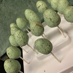 there are many green cake pops with brown speckles on them