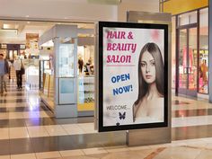 a sign advertising hair and beauty salon in a shopping mall, with people walking by