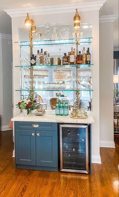 a bar with several bottles and glasses on the top shelf, along with an ice chest