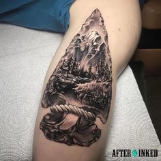 a black and white tattoo on the arm of a person with mountains in the background