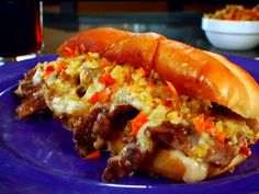 a blue plate topped with a sandwich covered in meat