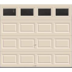 a white garage door with three windows on the top and bottom panel, in front of a