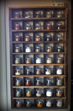 a wooden shelf filled with lots of different types of spices