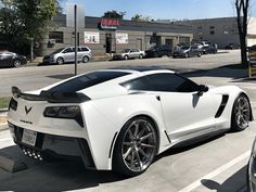 a white sports car is parked on the street