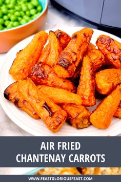 air fried chantenay carrots on a white plate with peas in the background