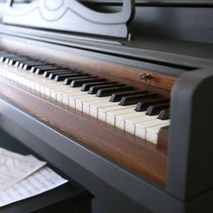 a close up of a piano with sheet music on the table