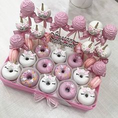 a pink box filled with lots of donuts covered in frosting