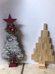 a small wooden christmas tree next to a smaller wooden christmas tree