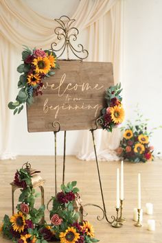 a sign that says welcome to the wedding with sunflowers and greenery