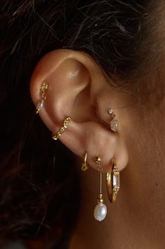 a close up of a person's ear with two different types of earrings on it