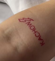 a person with a tattoo on their arm has the word kronhow written in red ink