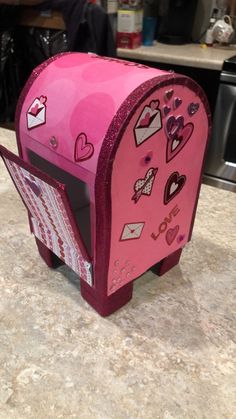 a pink heart shaped mailbox sitting on top of a counter