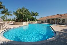 an empty swimming pool surrounded by palm trees