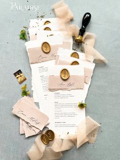 the wedding stationery is laid out on top of each other with waxed paper