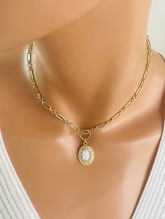 "This is a stunning 14k gold-filled choker chain necklace with a unique two-tone miraculous medal that hangs from toggle clasp in front.  This gorgeous pendant measures 24x15mm, is 925 Sterling silver with gold plating to give it a two-tone look. Made here is the USA by skilled silversmiths this pendant is absolutely incredible. This lovey paper clip chain is made of 14 karat gold filled or can be ordered and 925  sterling silver.  Links measure 8x4mm and 4mm, 3-1 pattern.  Model is wearing a 15\" choker length.  Please measure around your neck to where you want the toggle to land. Comes in a gift box, ready to present! Necklace maybe ordered with a 925 sterling silver chain. Not shown." Dainty Necklace With Miraculous Medal, Gold Miraculous Medal Jewelry, Elegant Miraculous Medal Necklace, Choker Chain, Necklaces Gold, Gold Charm Necklace, Charm Necklaces, Miraculous Medal, Chain Choker Necklace