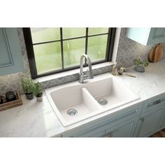 a white kitchen sink sitting under a window