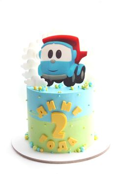 a birthday cake with a blue and green frosting on it's top, featuring a cartoon character