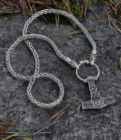 Vikings used necklaces with animals or beasts biting onto a ring where pendants were hung. This Sterling Silver variant is truly a majestic piece, ending bear heads based on the unique find in Eketorp, Sweden in 2017. The bears bite onto a ring with a Thor's Hammer covered by with lindworm designs, a Thurs rune and a triquetra symbol. #vikings #jewelry #mjolnir #grimfrost Luxury Silver Viking Style Jewelry, Triquetra Symbol, Vikings Jewelry, Viking Pendant, Thor's Hammer, Bear Head, Viking Jewelry, Infinity Bracelet, Ring Necklace