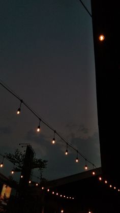 string lights are hanging from the side of a building at night with no one in sight