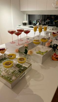 a kitchen counter topped with lots of glasses filled with different types of food and drinks