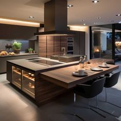 a modern kitchen with an island countertop and dining room table in the center, lighted by recessed lighting