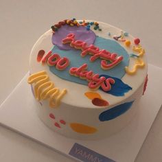 a birthday cake with the words happy 100 days written on it and colorful icing