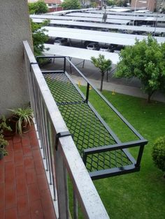 a balcony with metal railings and green grass