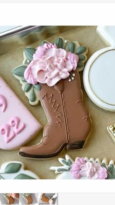 the cookies are decorated with pink flowers and cowboy boots on top of each cookie sheet