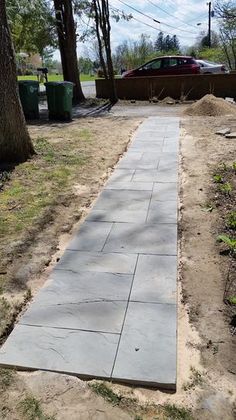 a concrete walkway in the middle of a yard