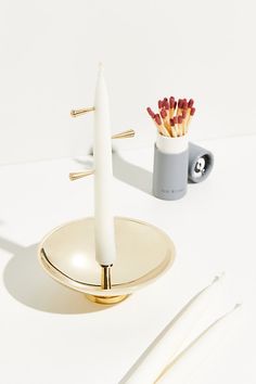 a white candle sits on top of a plate