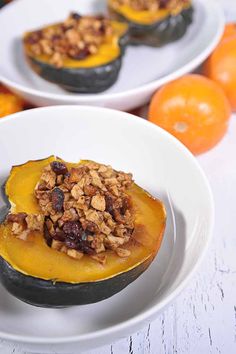 two white plates topped with baked goods on top of each other next to oranges