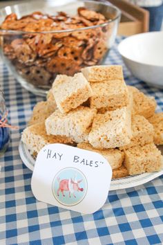 a table topped with lots of food next to a bowl filled with rice krispy treats