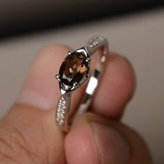 This is a gorgeous handmade creation. Its beauty is its simplicity & Elegance. The 5*7 mm oval shape faceted natural smoky quartz is crafted in solid sterling silver and with rhodium plated. All item is sent in a beautiful gift box If you have any idea of design your ring,pls contact me directly. You can realize more lovely stuff clicking the link https://www.etsy.com/shop/knightjewelry?refshopsection_shophome_leftnav Please leave the correct address and you phone number for delivering succe Cushion Cut Wedding Rings, Garnet Wedding Rings, Wedding Ring Cushion, January Birthstone Rings, Swiss Blue Topaz Ring, September Birthstone Rings, Blue Gemstone Rings, Brown Gemstone, Smoky Quartz Ring