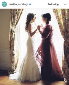 two women standing next to each other in front of a window with curtains on it